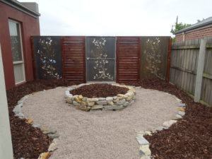 Low maintenance feature area with rock, mulch and corten screens